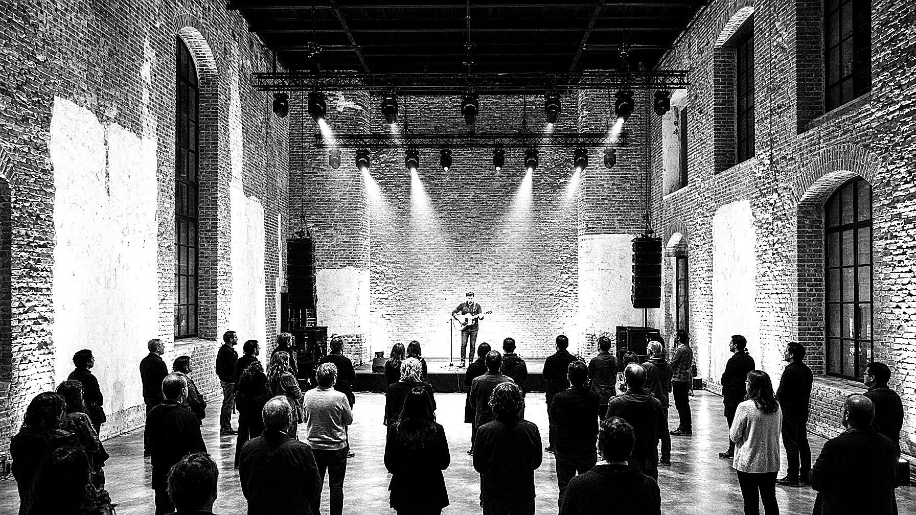 Concierto íntimo bajo un truss de luces, unas treinta personas